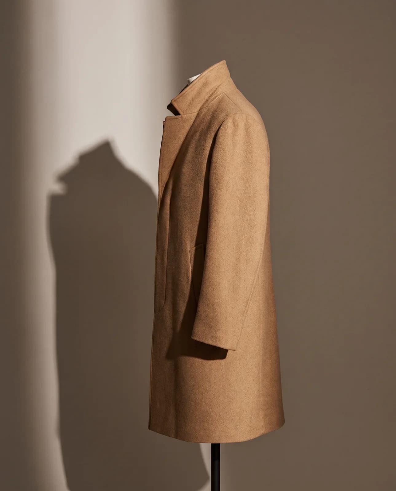 Camel overcoat on a stand in side light